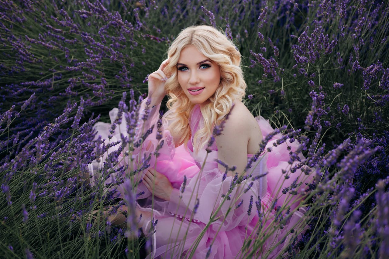 services-02 A beautiful woman in a pink dress surrounded by vibrant lavender flowers in a summer field.
